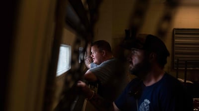 Firefighters look out the window from a shelter as hurricane Ida passes in Bourg. AFP