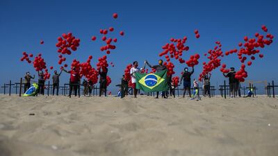 Demonstrators from the NGO 'Rio De Paz' release red balloons in Copacabana beach in Rio de Janeiro, Brazil. The demonstration is a tribute in memory of Brazilians killed by Covid-19. Getty Images