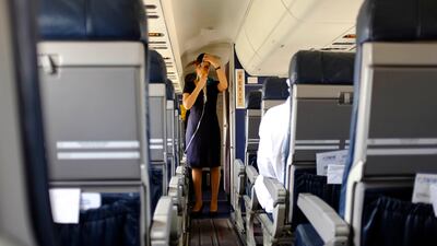 An air hostess demonstrates safety instructions before take-off.