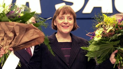 Angela Merkel cheering with flowers after being elected as the new leader of Christian Democratic Union, April 4, 2000. AFP