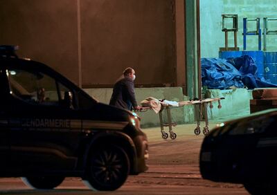 A man wheels a gurney into a warehouse in Calais, northern France, where the bodies of those who died in November 2021 were held. Getty Images