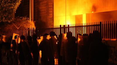 Lebanese police stand guard after demonstrators hurled petrol bombs at the central bank headquarters in the southern city of Sidon (Saida). AFP