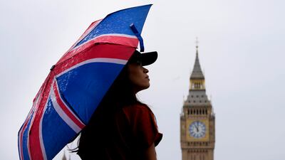 A woman opposite the Elizabeth Tower, also known as Big Ben, in London. AP