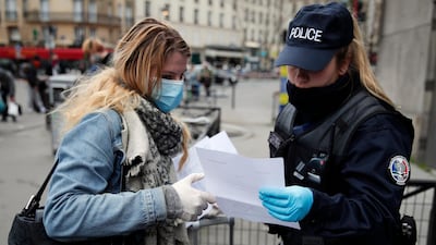 A French police officer checks a passenger's permission to leave home as she embarks a train at Montparnasse station in Paris, on March 21, 2020. AP Photo