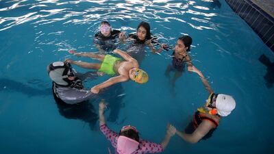 Coach Elaf teaches children to be confident in the water. Reuters
