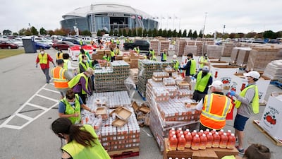 Volunteers build bags of dry goods in a parking lot outside of AT&T Stadium during a Tarrant Area Food Bank mobile pantry distribution event in Arlington, Texas. AP Photo