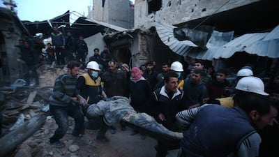 Members of the Syrian Civil Defence Forces, known as the White Helmets, evacuate an air strike victim in the rebel-held enclave of Arbin, Eastern Ghouta, on February 9, 2018. Abdulmonam Eassa / AFP