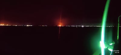 Seafarers on a bulk carrier anchored near Bandar Abbas witness strikes on the Iranian coast. Photo: Ankit Goyal