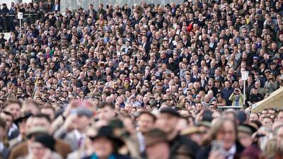 Crowds watch the action during day one of the Cheltenham Festival. PA