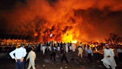 Pakistani policemen and onlookers gather as a cloud of smoke billows from the burning Marriott hotel following a powerful bomb blast in Islamabad on Sept 20 2008.