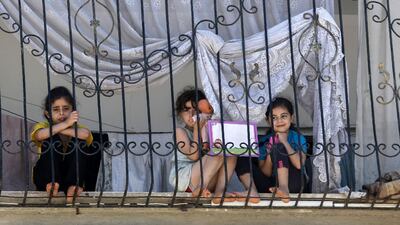 Young Palestinian girls sit at the window sill in Gaza City amid the coronavirus pandemic crisis. AFP