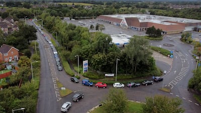 Motorists queue for a petrol station to open at a Tesco in Ashford, Kent on October 3