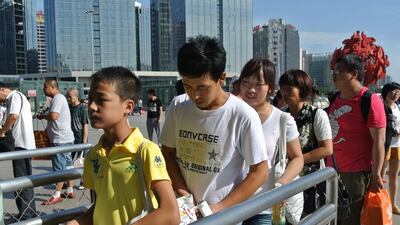 Du Shuangyan´s parents accompany Du into the Beijing West Railway station after he went to visit them in the Chinese capital. He is one of an estimated 60 million children in China left behind by their parents who have to go go to the cities in search of better paid work. Emily Zeng for The National
