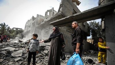 Palestinians collect their belongings from the rubble of a residential building destroyed by an Israeli air strike in the Maghazi refugee camp in central Gaza. AP