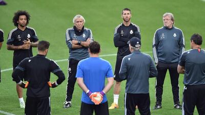 Real Madrid players listen to manager Carlo Ancelotti (facing away with baseball cap, centre) during their team training session on Monday for Tuesday's Champions League semi-final first leg match against Juventus in Turin. Alessandro Di Marco / EPA