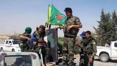 Kurdish fighters of the YPG sit on their pickup in the town of Ein Eissa, north of Raqqa city, Syria. The Kurdish fighters of the People's Protection Units via AP Photo