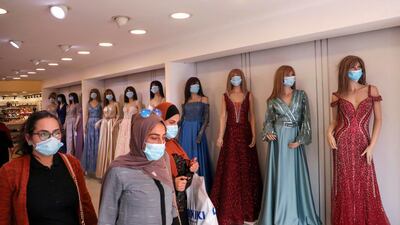 Palestinian women wearing protective masks amid the COVID-19 pandemic, shop at a clothing store as Muslims prepare for the Eid al-Adha feast, in the West Bank city of Hebron. AFP