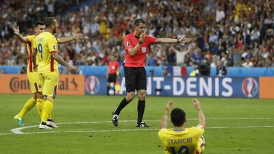 Referee Viktor Kassai awards a penalty after Romania’s Nicolae Stanciu was fouled by France’s Patrice Evra. Lee Smith / Reuters