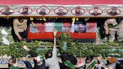 A mourner touches the coffin of one of the slain members of the IRGC. EPA