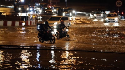Motorists try to get through flooding on a roundabout near Studio city in Dubai. Chris Whiteoak / The National