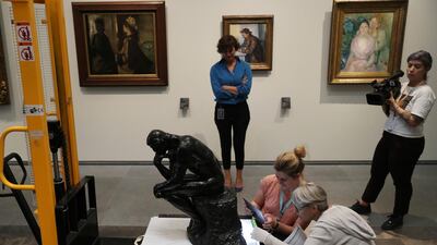 Dr Souraya Noujaim, the Scientific, Curatorial and Collections Management Director, who is the person in charge of all of Louvre Abu Dhabi's collection, center back, supervises the examination of Rodin's 'Thinker' bronze statue after removal from it's package to install it at the Louvre Museum in Abu Dhabi. Kamran Jebreili / AP photo