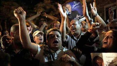 Egyptian supporters chant slogans and carry posters with pictures of presidential runoff candidate Ahmed Shafiq in front of his ransacked campaign headquarters in Cairo.