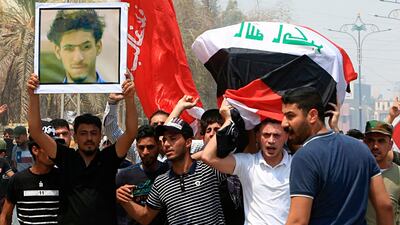Mourners chant anti government slogans while carry the Iraqi flag-draped coffin of Mekki Yasser, seen in the poster, a protester whose family and activists said he was killed when he participated in a protest last night, during his funeral on Tuesday, Sept. 4, 2018, in Basra, about 340 miles (550 kilometers) southeast of Baghdad, Iraq. (AP Photo/Nabil al-Jurani)