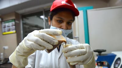 A quality control technician inspects a chocolate sample at the Havmor Ice Cream plant at Naroda near Ahmedabad in India. Sam Panthaky / AFP