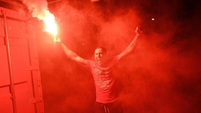 Fans celebrate Liverpool winning the Premier League title outside Anfield stadium. AFP