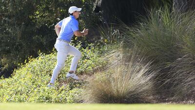 McIlroy looks for his ball on the tenth hole. AFP
