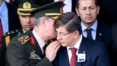 Turkey’s chief of staff Gen Hulusi Akar talks to the prime minister, Ahmet Davutoglu, as they attend the funeral on February 18, 2016, of a soldier killed south-eastern city of Diyarbakir. Adem Altan / AFP
