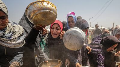 Palestinians receive food from a charity kitchen in Jabalia refugee camp, northern Gaza, on May 9. EPA