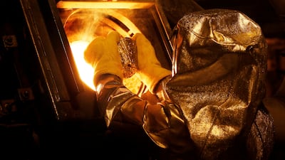 A refinery technician puts a gold 'button' into a furnace at Newmont Mining's Carlin gold mine operation in the US. The precious metal is often considered a safe haven by investors when inflation rises. Reuters