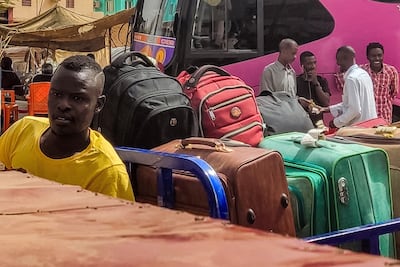 A man on a motorcycle loaded with suitcases as people prepare to leave on buses from southern Khartoum this week. AFP