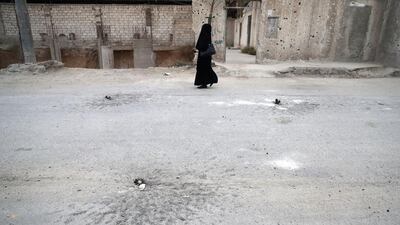 A fully-veiled woman walks past unexploded mortar shells in the rebel-held town of Douma on the eastern outskirts of the Syrian capital Damascus. Douma, the largest town in the Eastern Ghouta area with more than 100,000 residents, is surrounded and regularly shelled by regime forces. Abd Doumany / AFP
