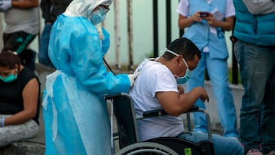 A health worker checks a patient with symptoms related to Covid-19 at the coronavirus unit of the San Juan de Dios Hospital in Guatemala City. AP Photo