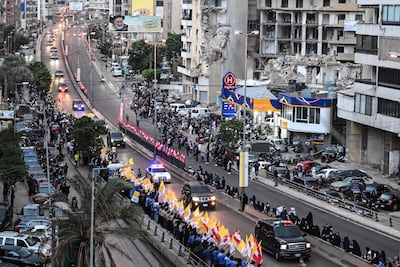 Pope Leo's convoy drives past damaged buildings in the south of Beirut. AFP