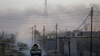 Iraqi soldiers drive tanks during clashes with ISIL fighters in Al-Qasar.