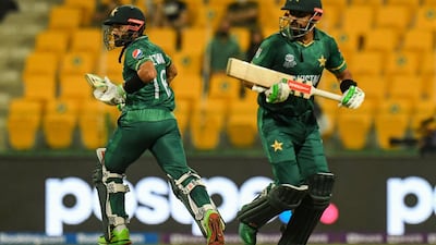 Pakistan's wicketkeeper Mohammad Rizwan (L) and Babar Azam run between the wickets during the ICC men’s Twenty20 World Cup cricket match between Namibia and Pakistan at the Sheikh Zayed Cricket Stadium in Abu Dhabi on November 2, 2021. (Photo by INDRANIL MUKHERJEE / AFP)