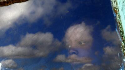 A local boy, Anda, looks out from a window at the burial ground of late former South African President Nelson Mandela ahead of his funeral in Qunu. Yannis Behrakis / Reuters
