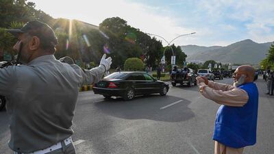 Security personnel escort Mr Khan's car to the Supreme Court in Islamabad. AFP