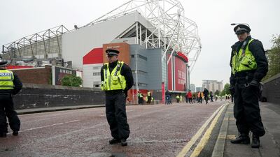 Police and security staff stand guard outside Old Trafford on Thursday. Getty