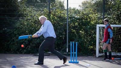 Britain's Prime Minister Boris Johnson takes part in a game of cricket in a sports lesson during a visit to Ruislip High School in his constituency of Uxbridge, west London, on September 28. Stefan Rouseau/PA via AP
