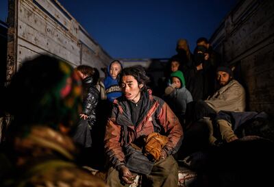 A suspected ISIS member sits in the back of a truck as he waits to be searched by members of the Syrian Democratic Forces after leaving Baghouz. AFP/Bulent KILIC