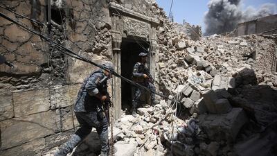 Iraqi federal police advancing through the old city of Mosul to retake the last district held by ISIL. Ahmad Al Rubaye / AFP