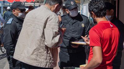 A Moroccan police officer confronts curfew violators in Rabat. EPA