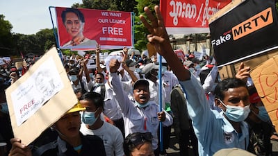Protesters hold up signs during a demonstration against the military coup in front of the Chinese embassy in Yangon. AFP