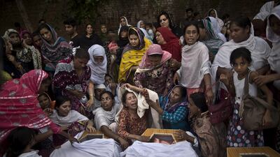 Pakistani women grieve over the coffins of their relatives killed in a suicide attack on a church in Peshawar. Muhammed Muheisen / AP