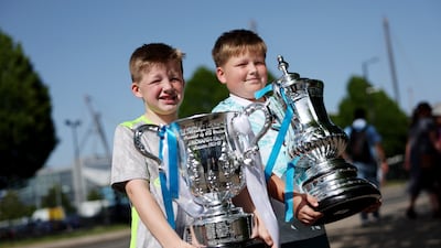 Young City fans with replicas of the FA Cup and League Cup. Getty Images