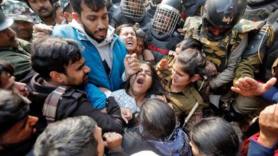 Demonstrators scuffle with police as they try to cross barricades during a protest against a new citizenship law outside the university in New Delhi, India. Reuters
